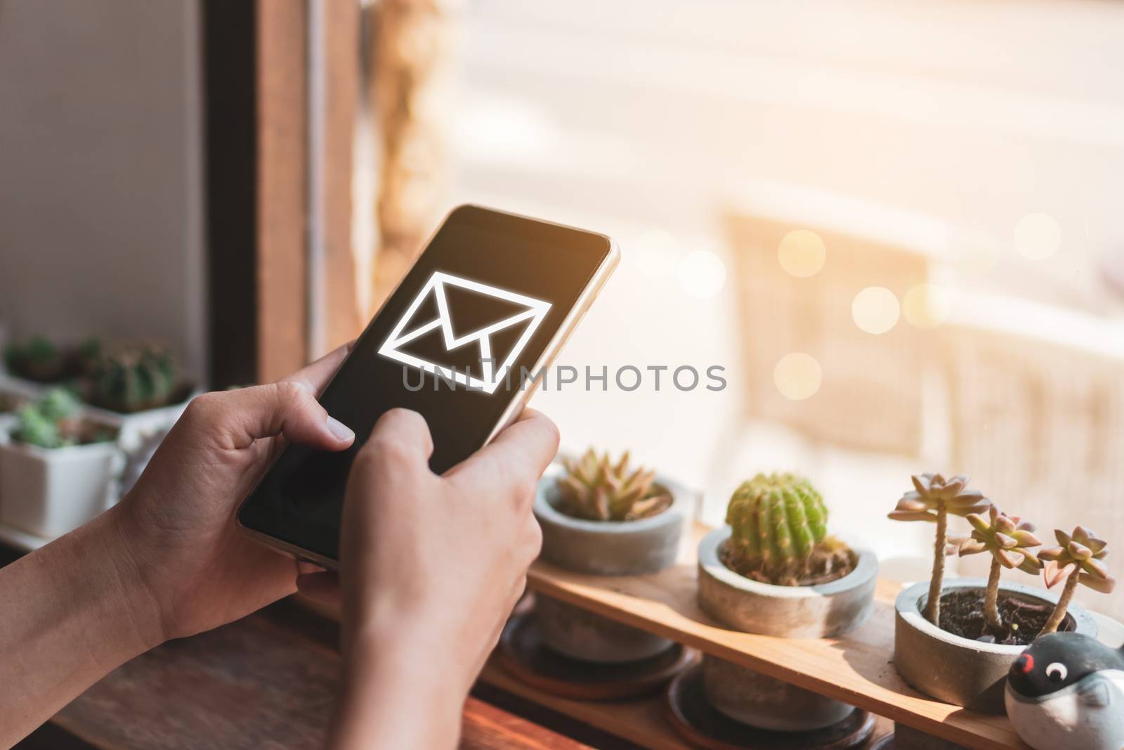 Woman hand using smartphone and it's show email recieve notification icon pop up on screen of mobile phone. Business communication  technology concept.