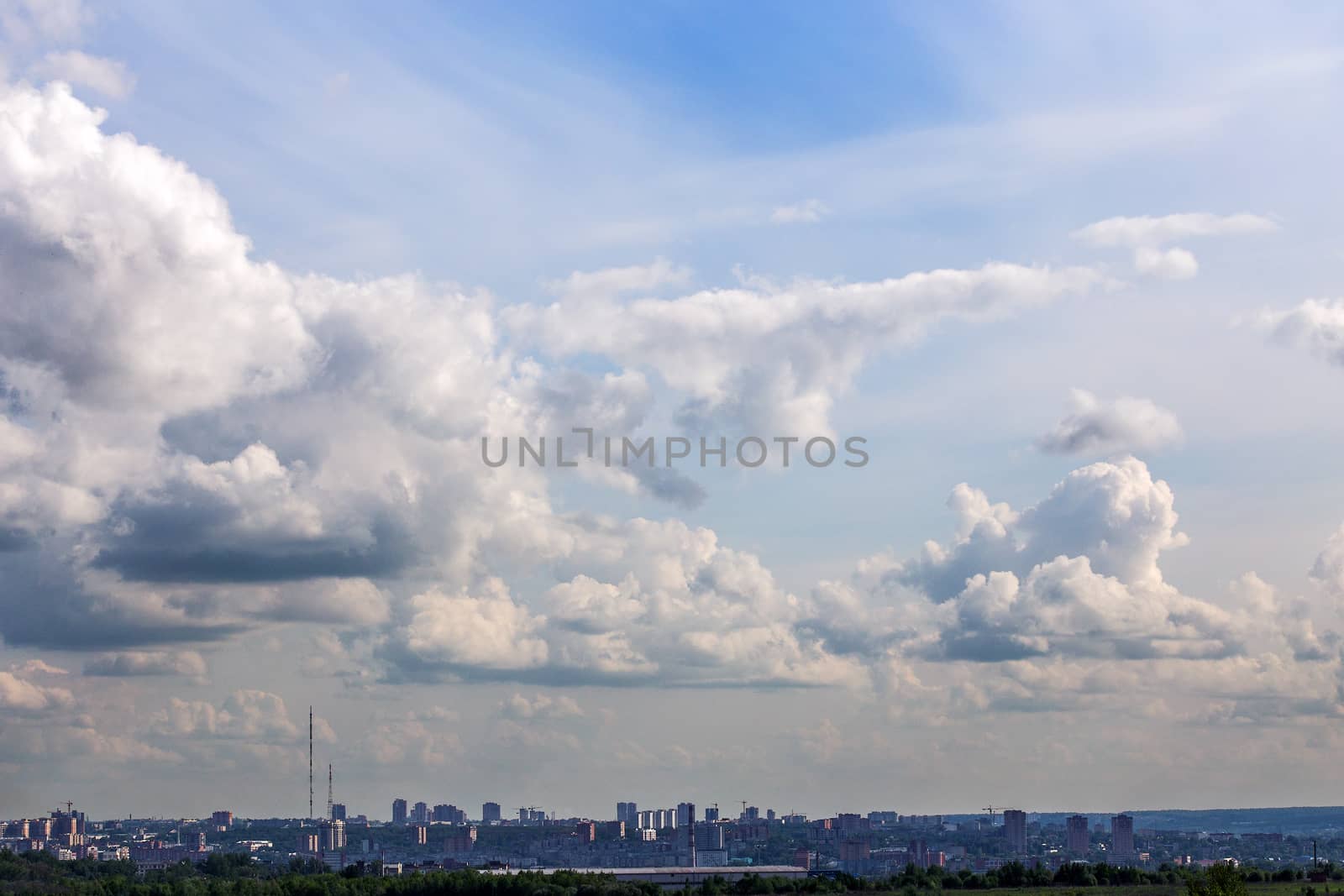 russian summer daylight cityscape with large cumulus clouds and tiny horizon line of the panel condominium houses.