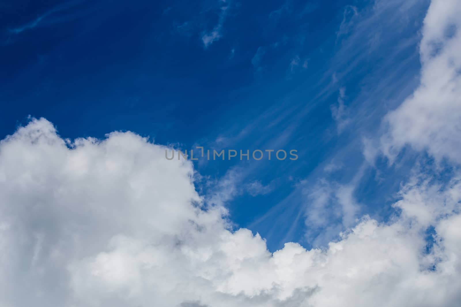 Regular spring clouds on blue sky at daylight in continental europe. Close shot wit telehoto lens and circular polarizing filter.