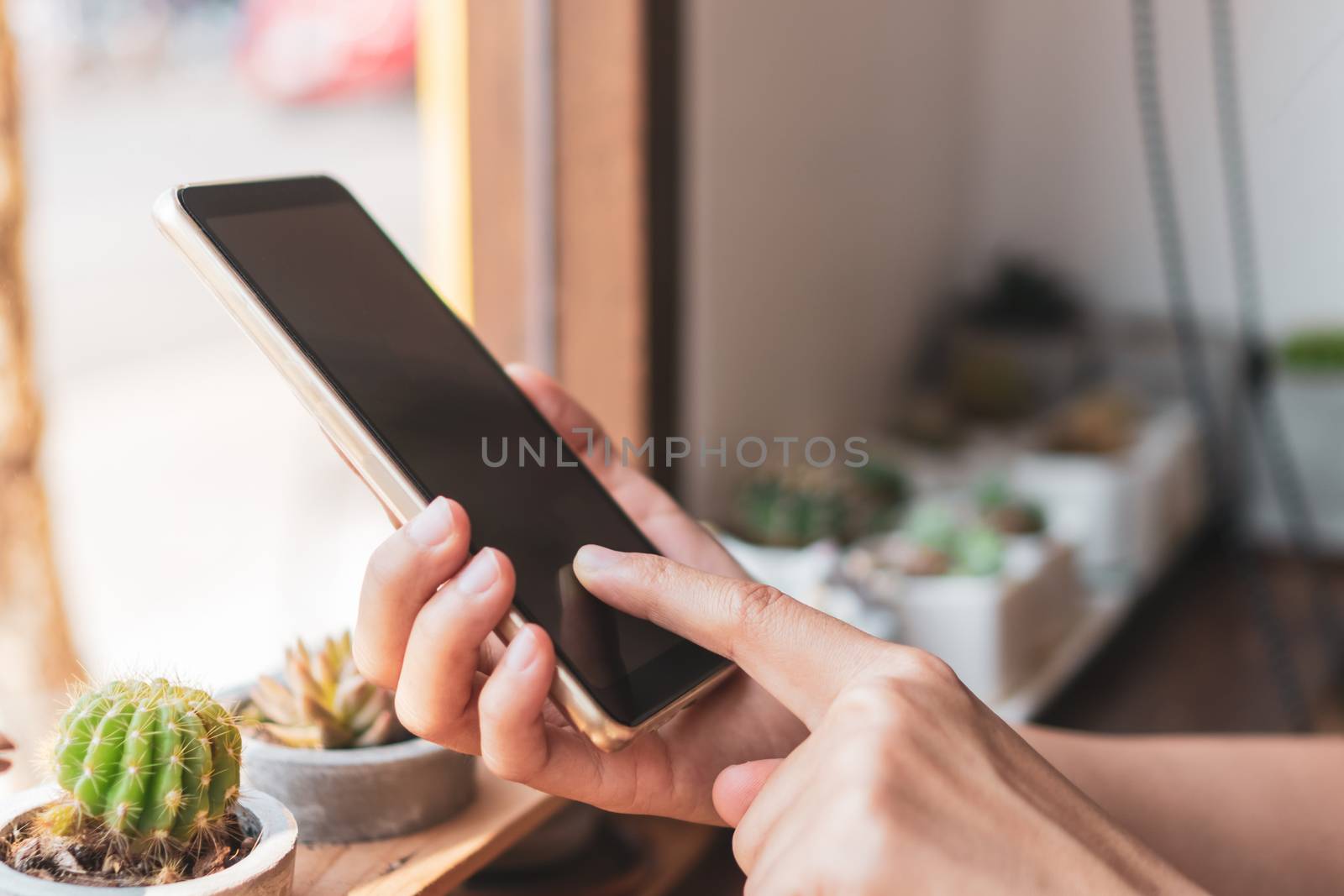 Woman hand use smartphone to do work business, social network, communication in public cafe work space area.