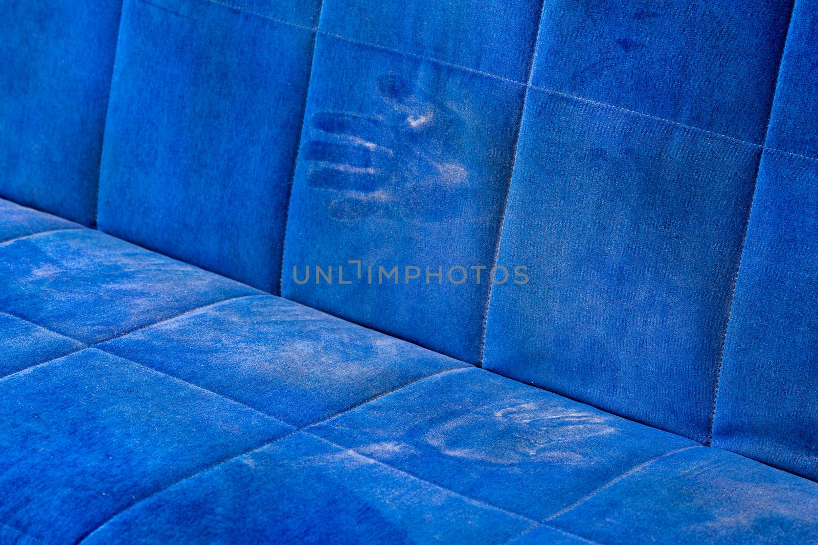 dusty blue sofa surface with palm prints closeup with selective focus.