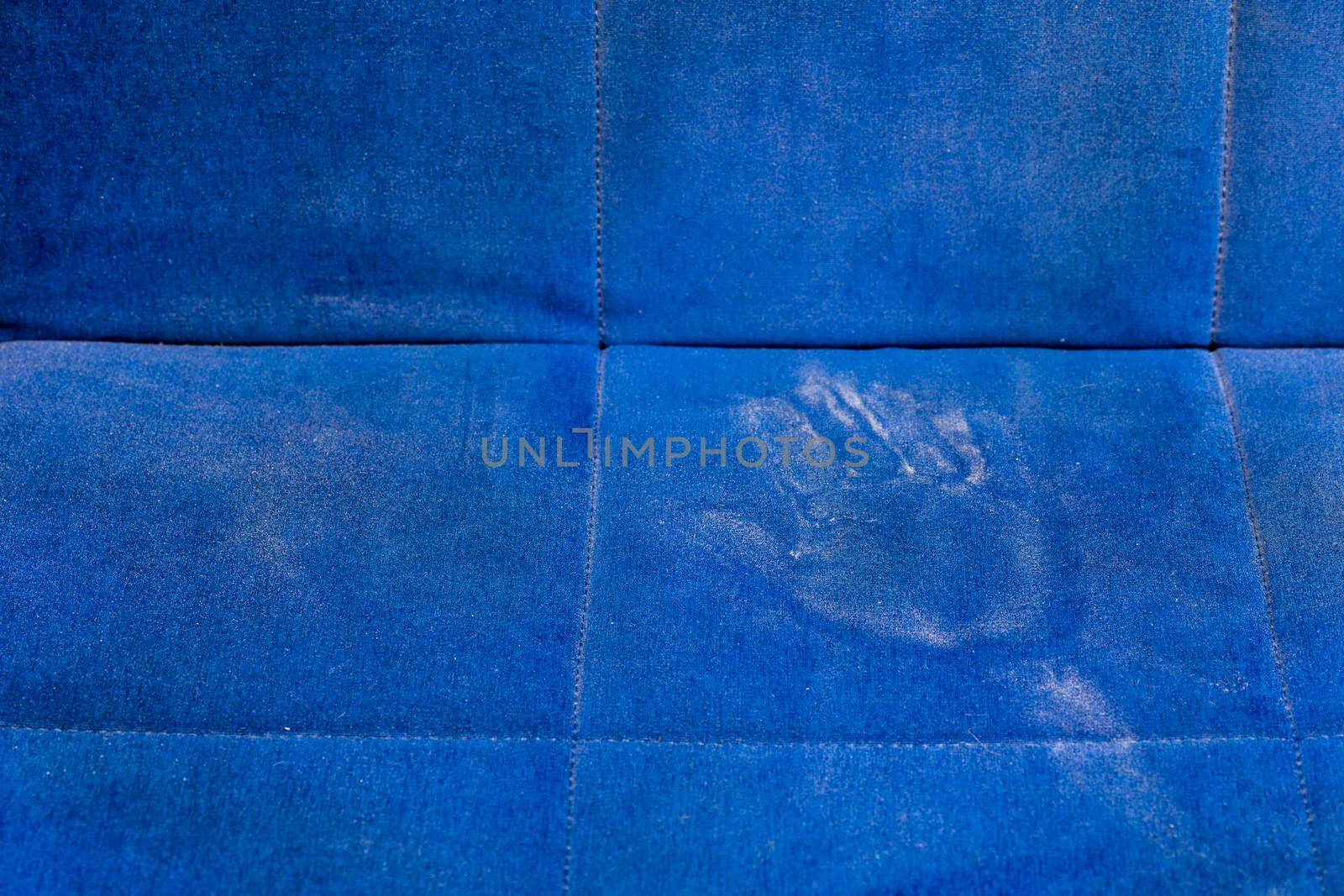 dusty blue sofa surface with palm prints closeup with selective focus.