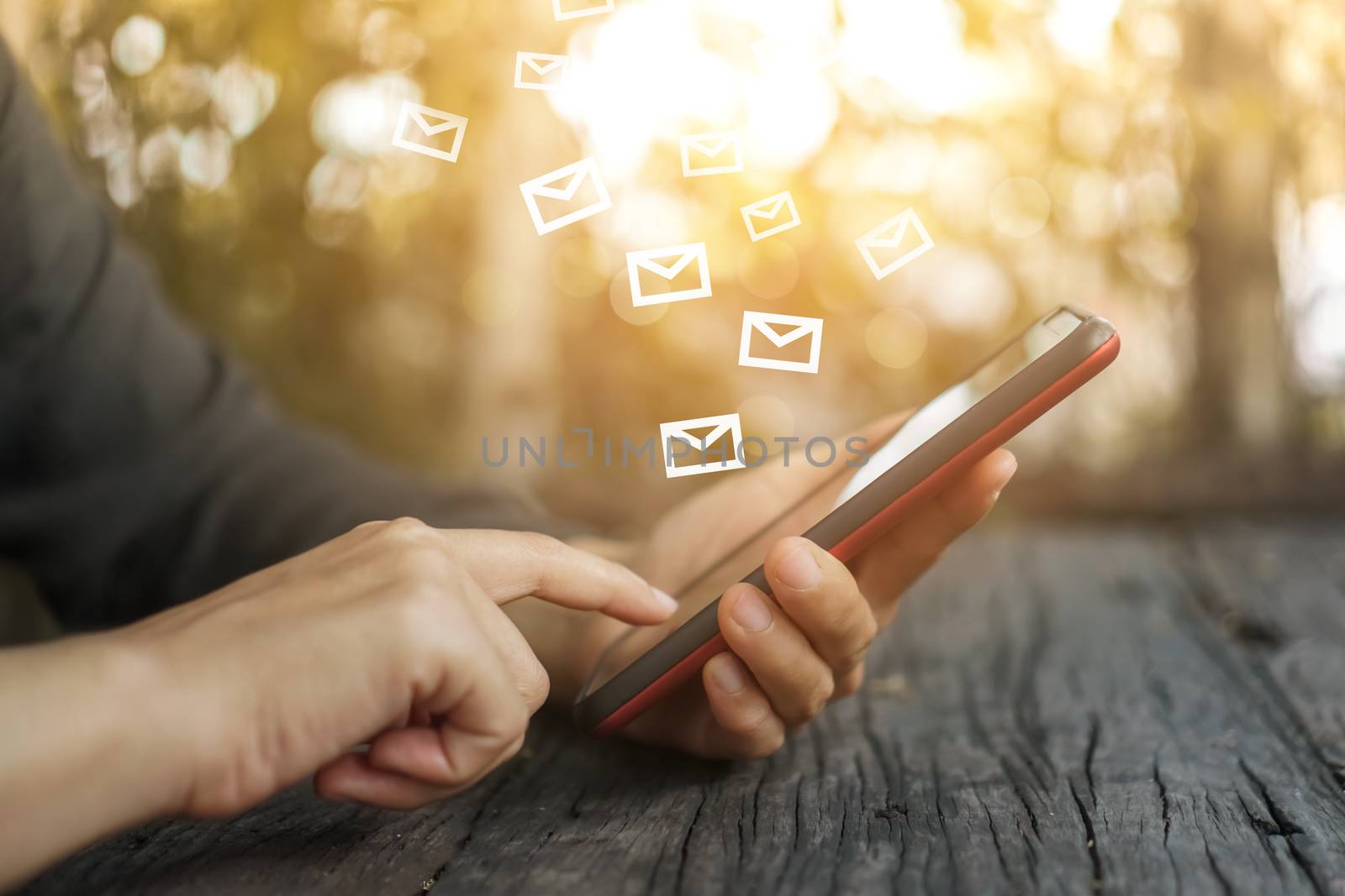 Woman hand using smartphone to send and recieve email for business on bokeh vintage color tone background.