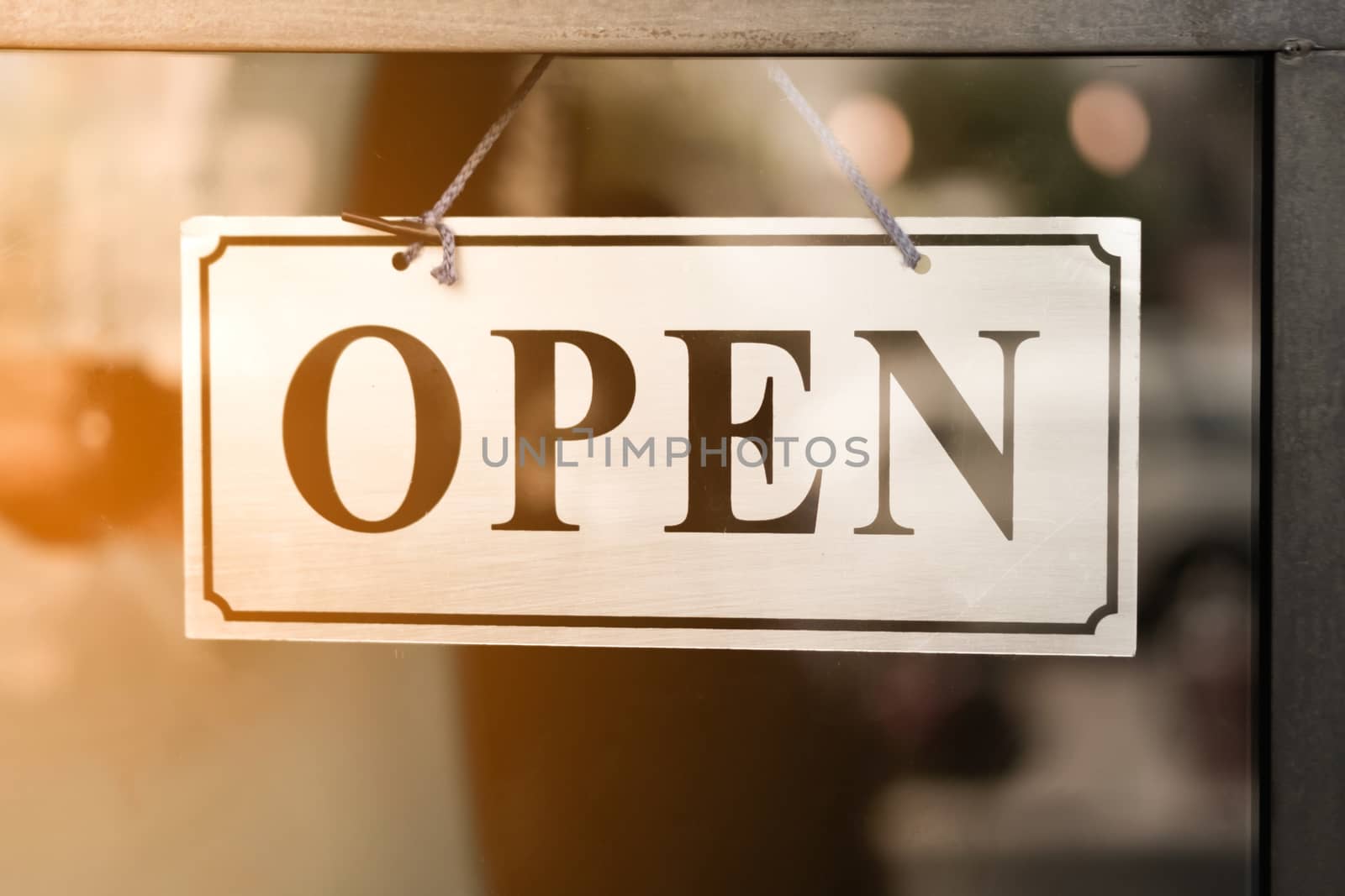 A business sign that says open on cafe or restaurant hang on door at entrance. Vintage color tone style.