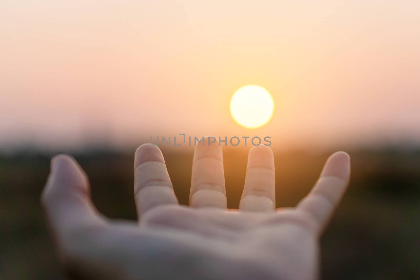 Woman hands place together like praying in front of nature blur beach sunset sky background.