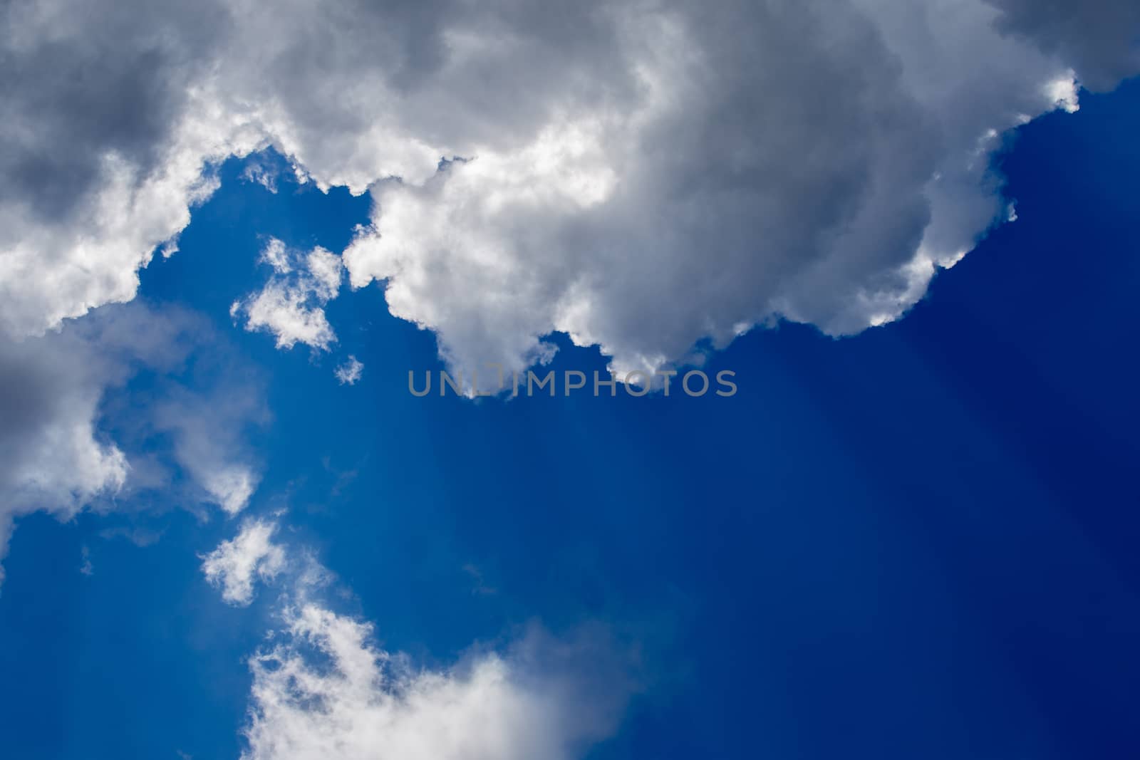 Regular spring clouds on blue sky at daylight in continental europe. Close shot wit telehoto lens and circular polarizing filter.