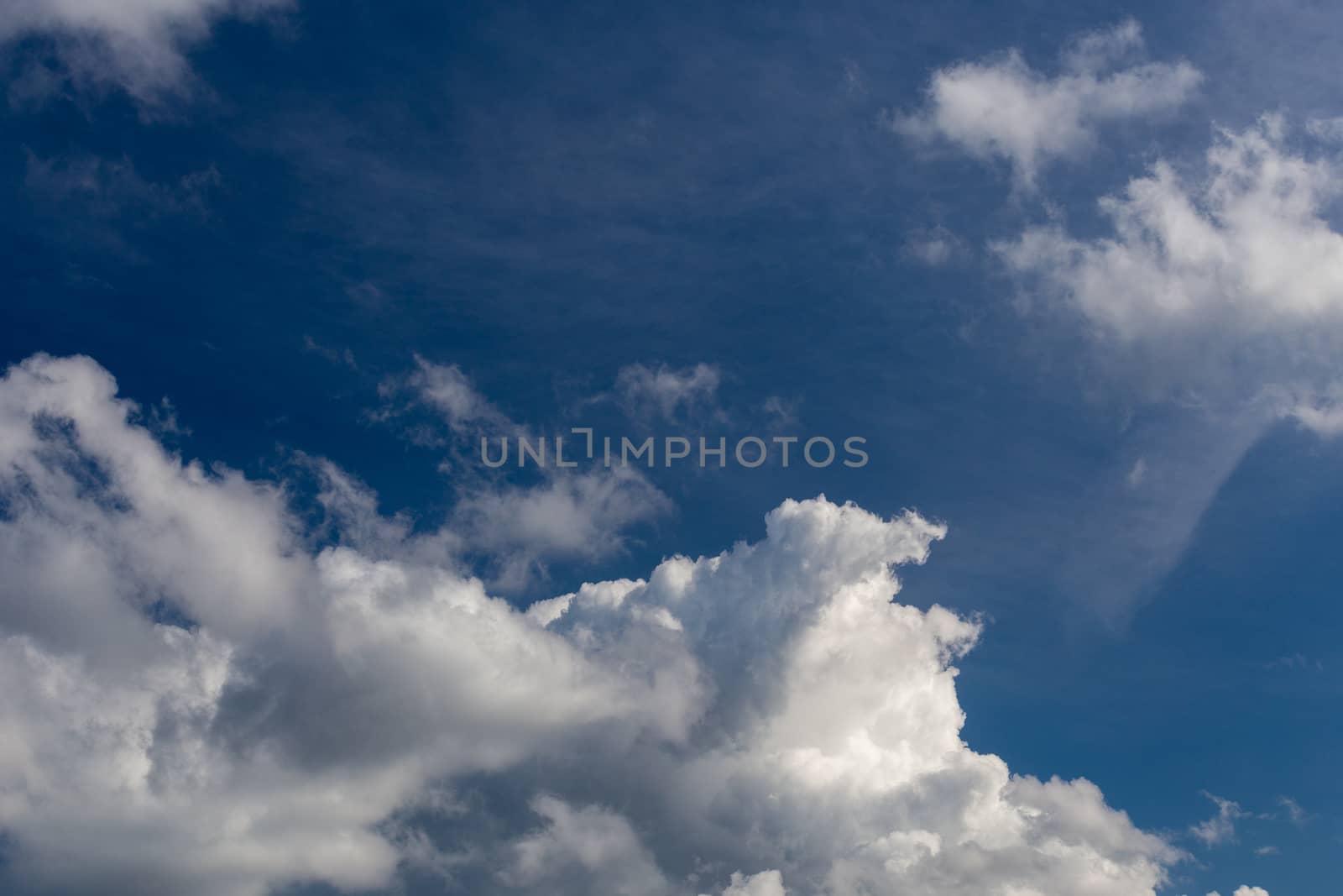 Regular spring clouds on blue sky at daylight in continental europe. Close shot wit telephoto lens and circular polarizing filter.