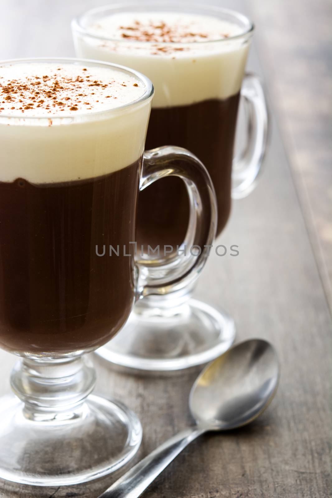 Irish coffee in glass on wooden table by chandlervid85