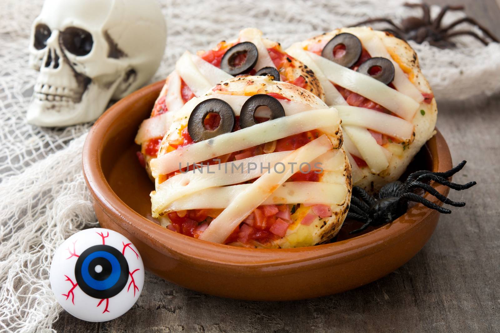 Halloween mummies mini pizzas on wooden table. by chandlervid85
