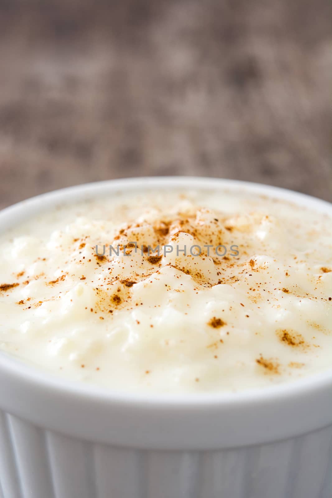 Arroz con leche. Rice pudding with cinnamon on wooden background