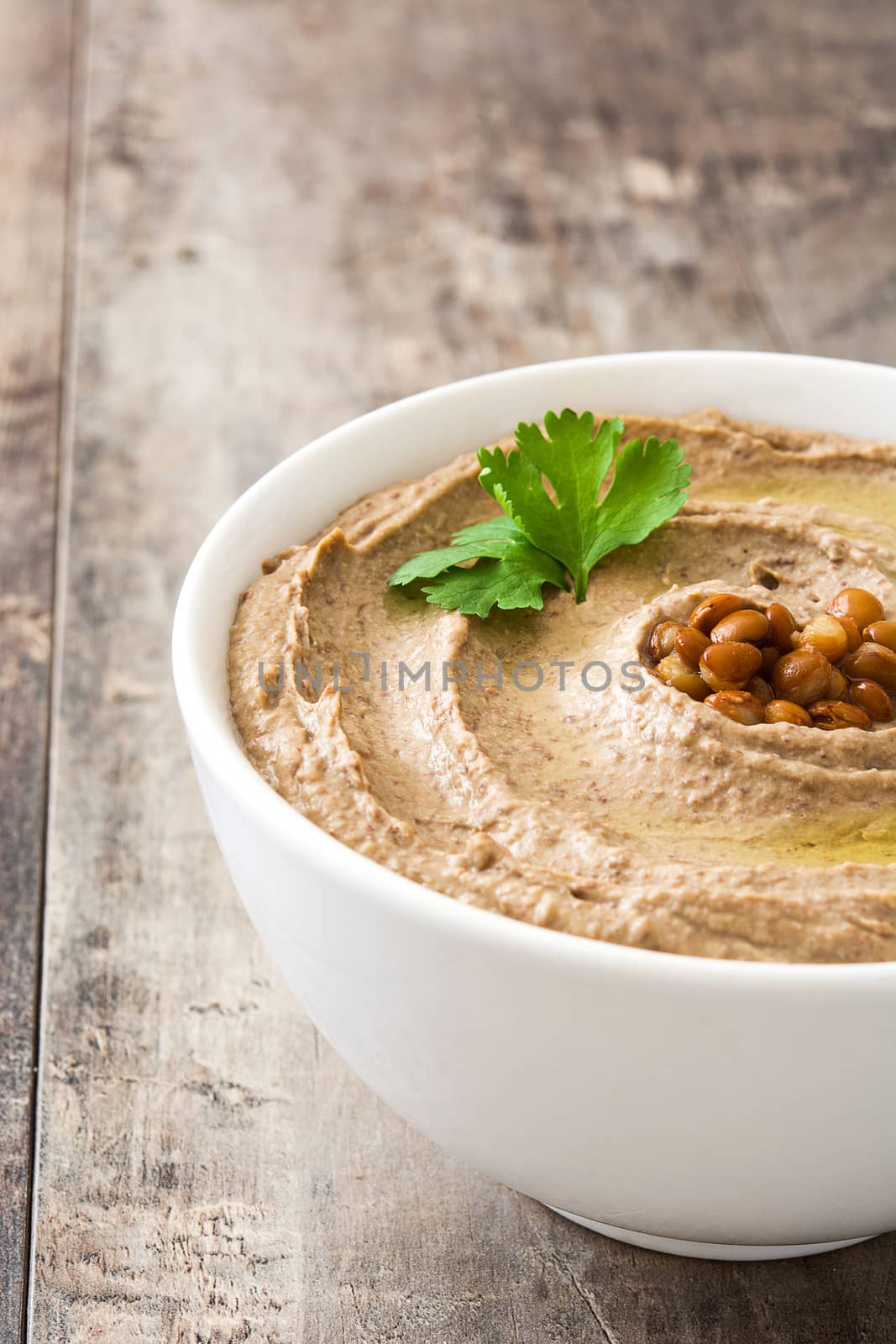 Lentil hummus in bowl on wood