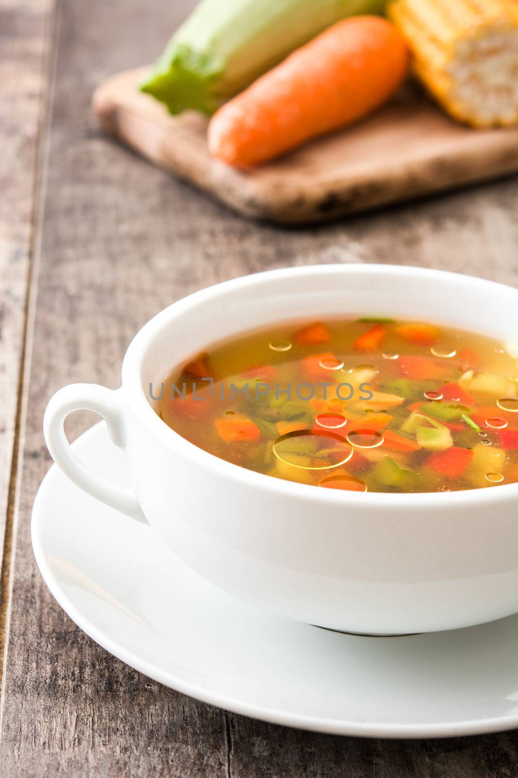 Vegetable soup in bowl on wooden table by chandlervid85