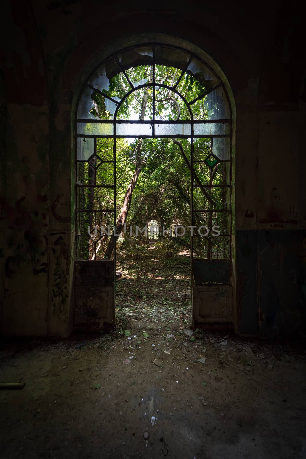 Arched door with broken windows in an old dilapidated Italian building of the twentieth century, urbex image