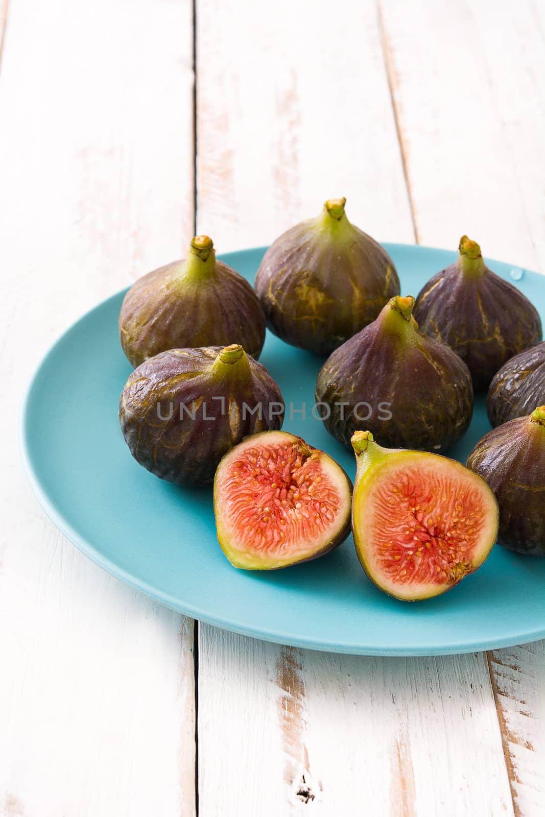 Fresh figs on white wooden background