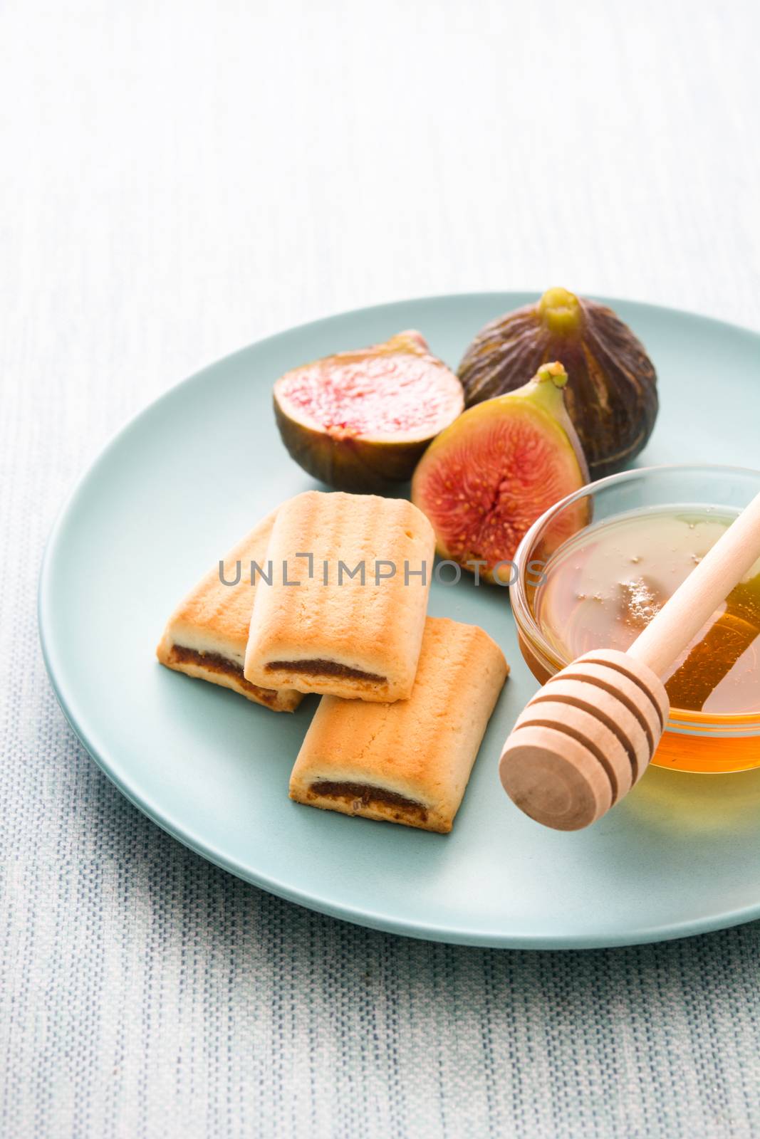 Fig cookies with honey on blue background