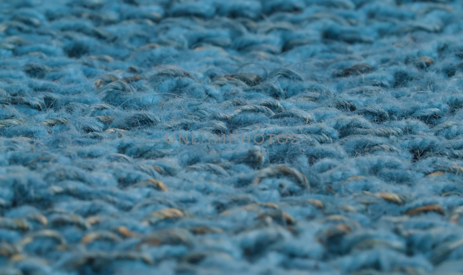 Extreme close up blue wool knitted fabric. Texture, textile background. Macro shooting, camera slowly moving along the cloth on slider.