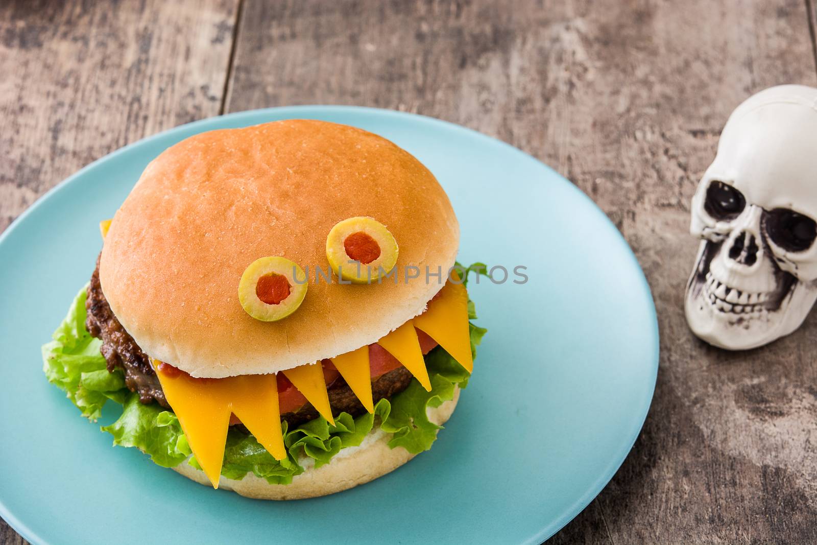 Halloween burger monsters on wooden table