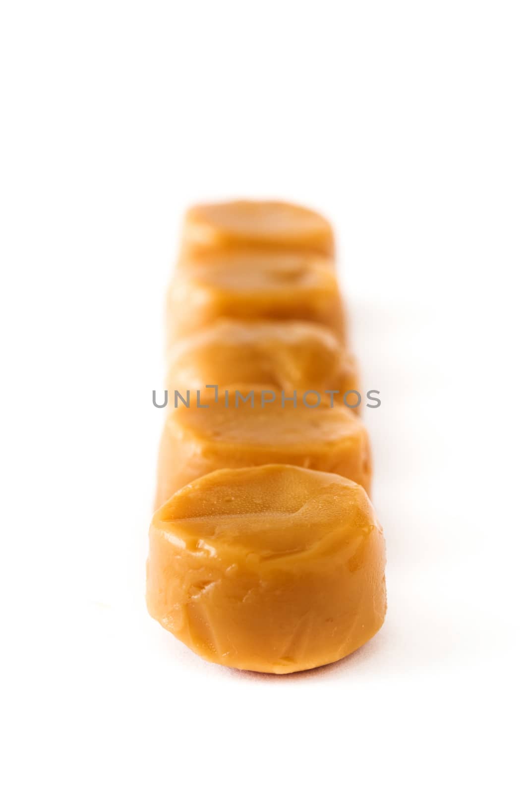 Toffee caramel candies isolated on white background. Copyspace. by chandlervid85