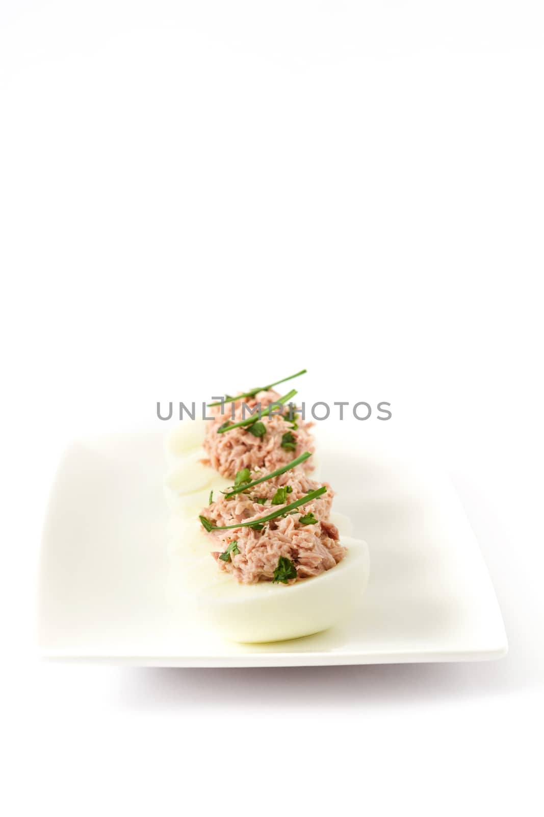 Stuffed eggs with tuna isolated on white background by chandlervid85