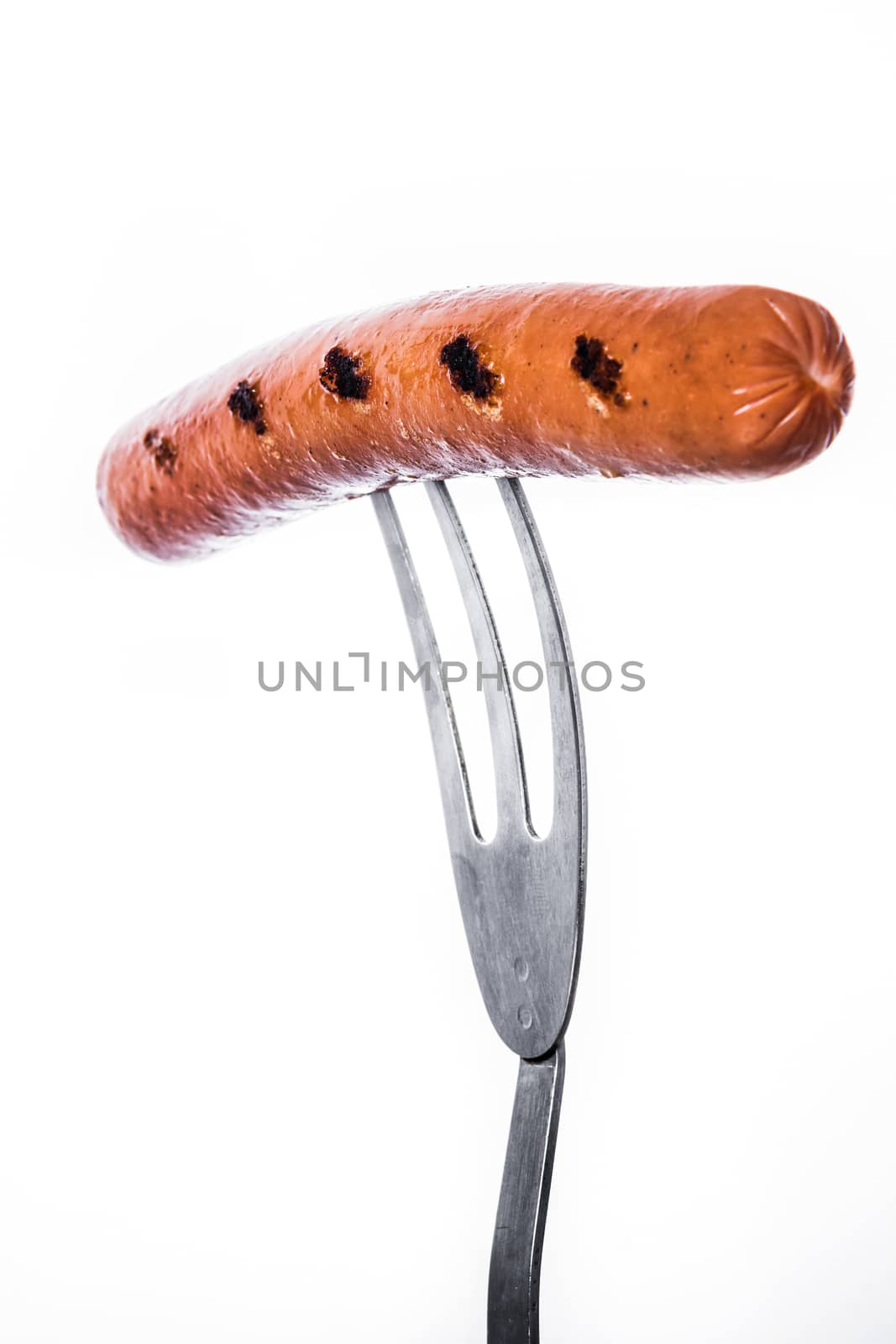 Grilled sausage on a fork isolated on white background