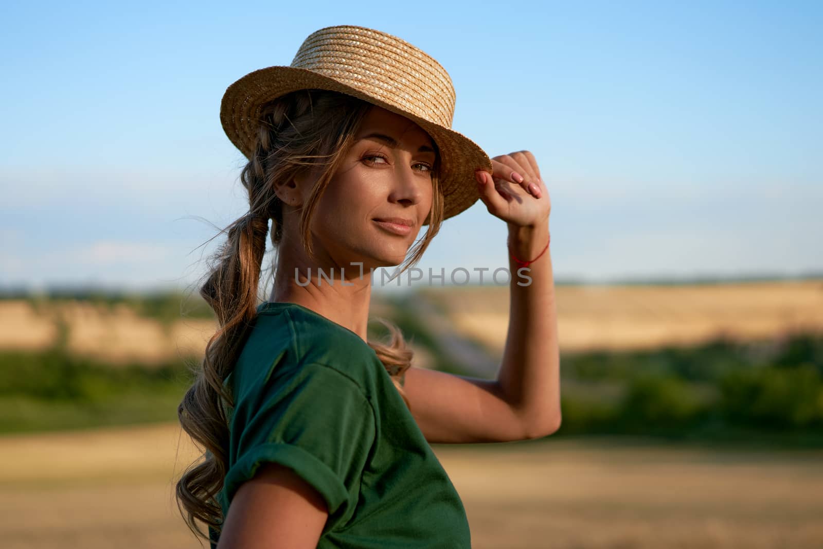 Woman farmer straw hat standing farmland smiling Female agronomist specialist farming agribusiness Happy positive caucasian worker agricultural field Pretty girl denim jeans green t-shirt harvest
