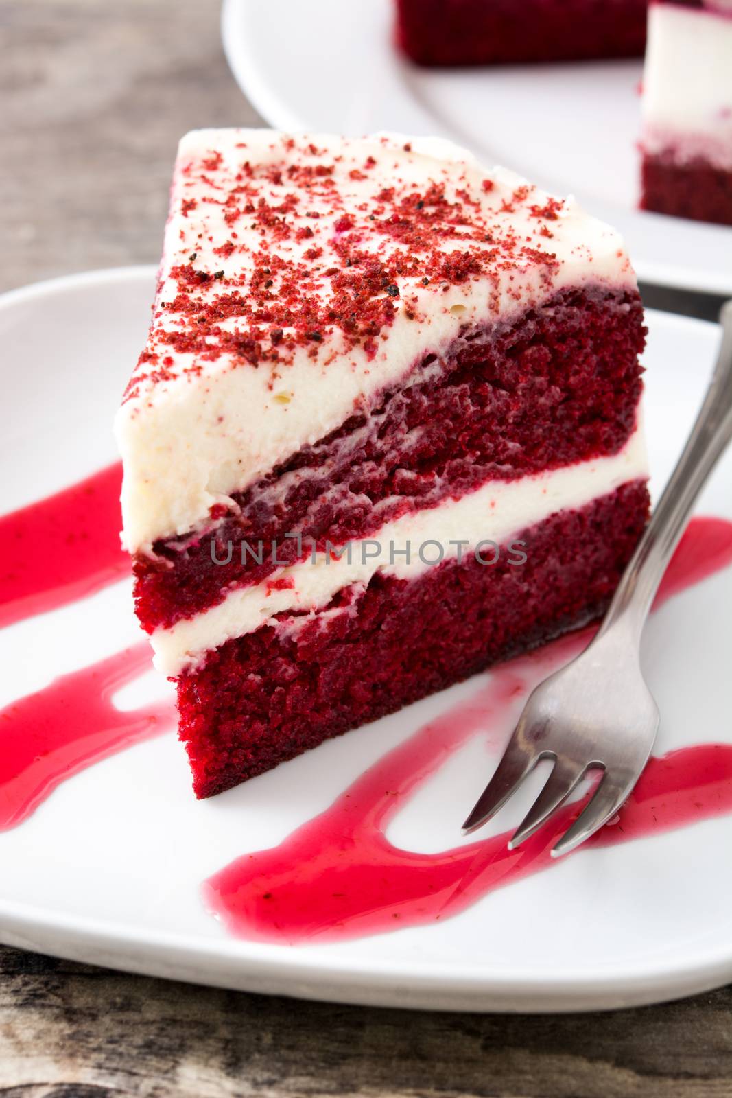 Red Velvet cake slice on wooden table.