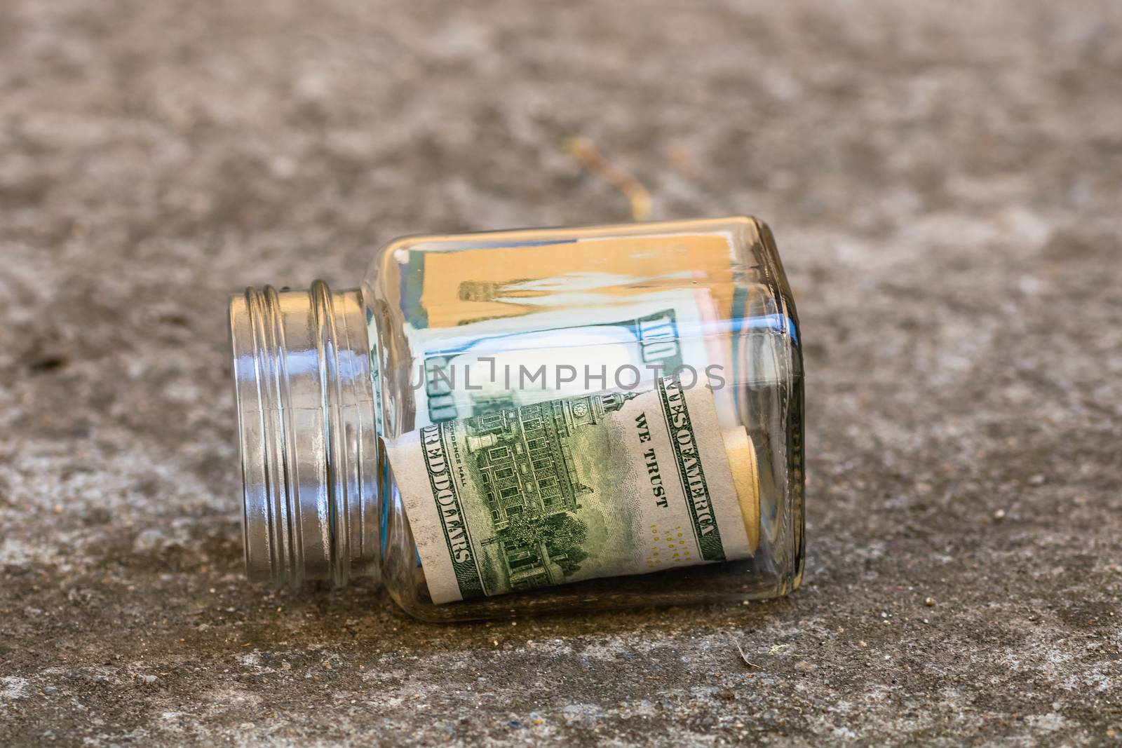 Composition with saving money banknotes in a glass jar. Concept of investing and keeping money, close up isolated.