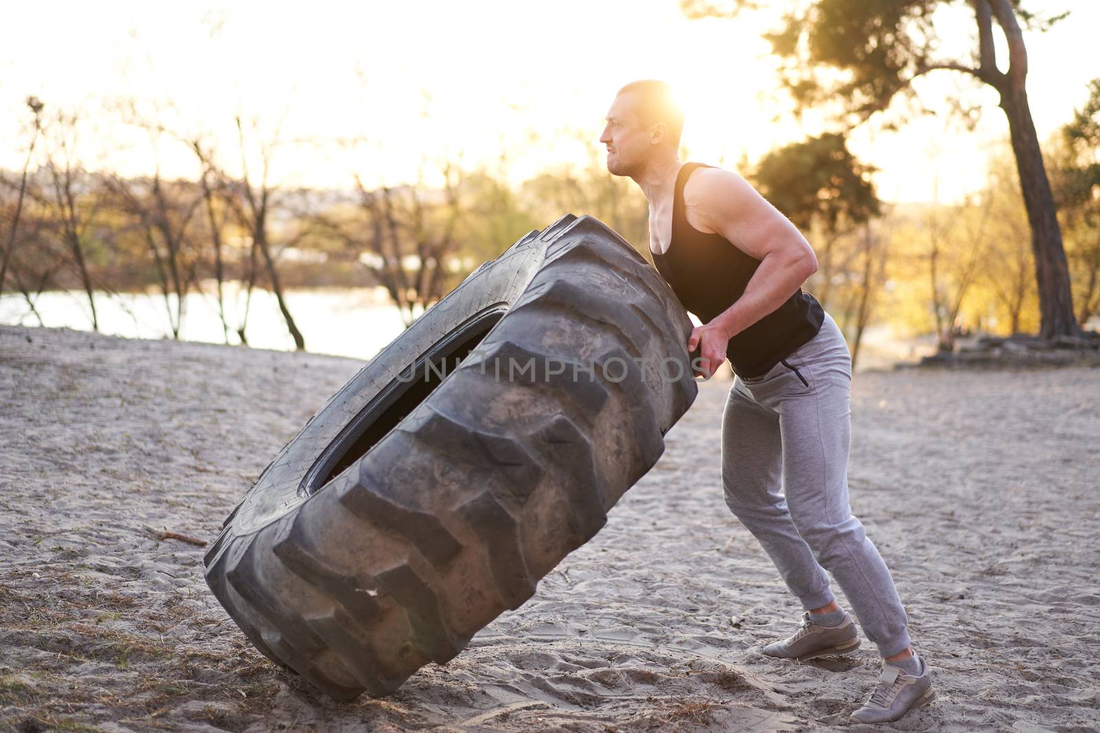 Strong man training workout lifting large tire outdoor DIY gym. by andreonegin