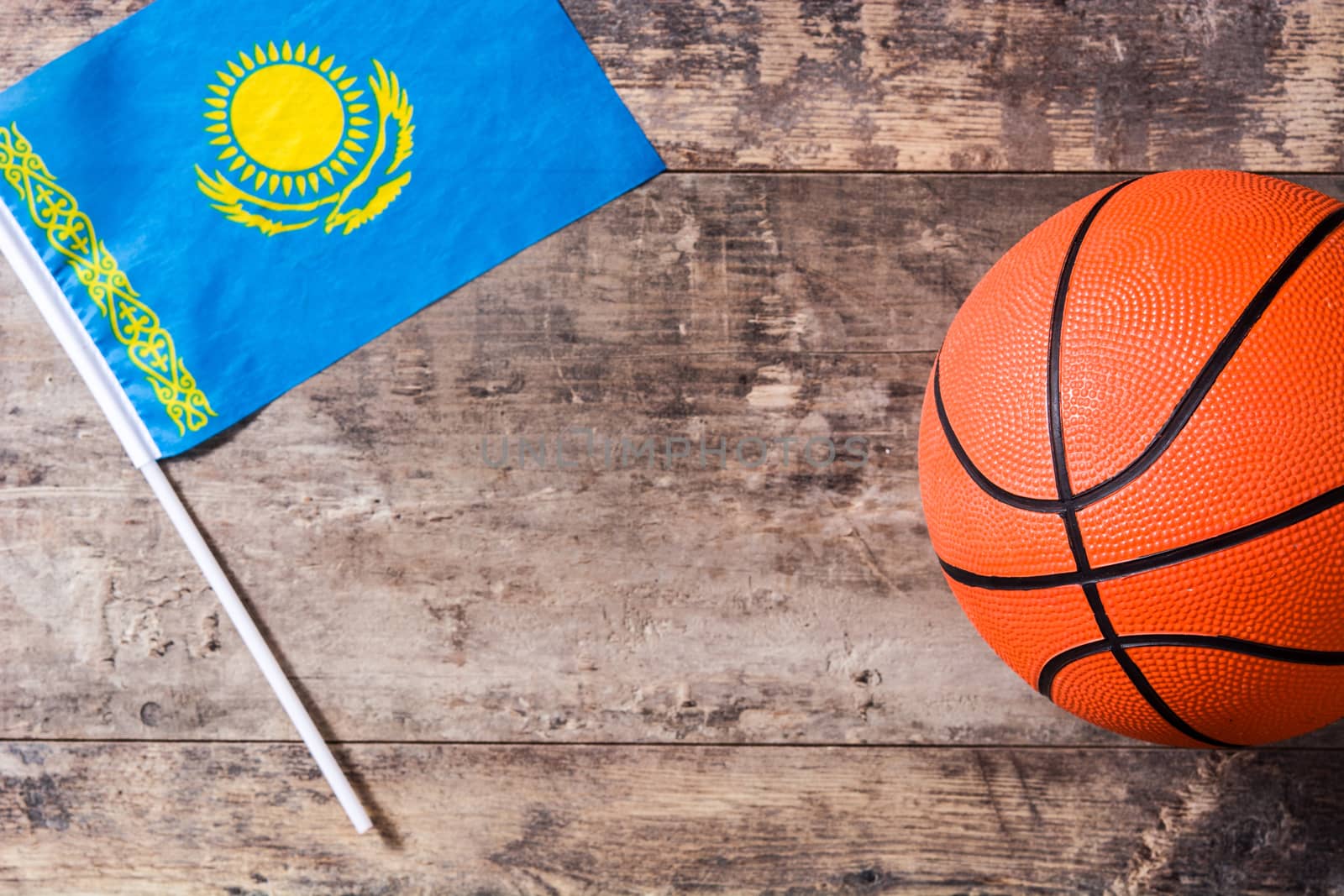 Kazakh flag and basketball on wooden table