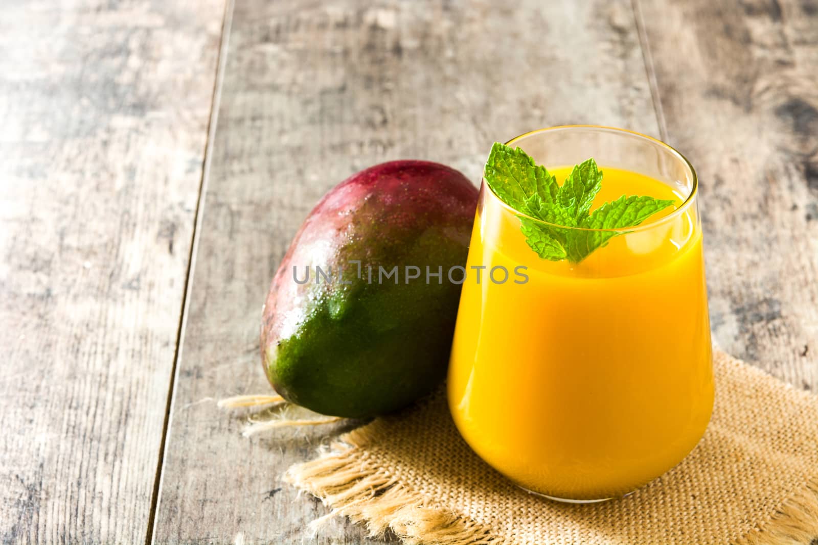 Mango Lassi dessert. Traditional Indian drink on wooden table. Copyspace
