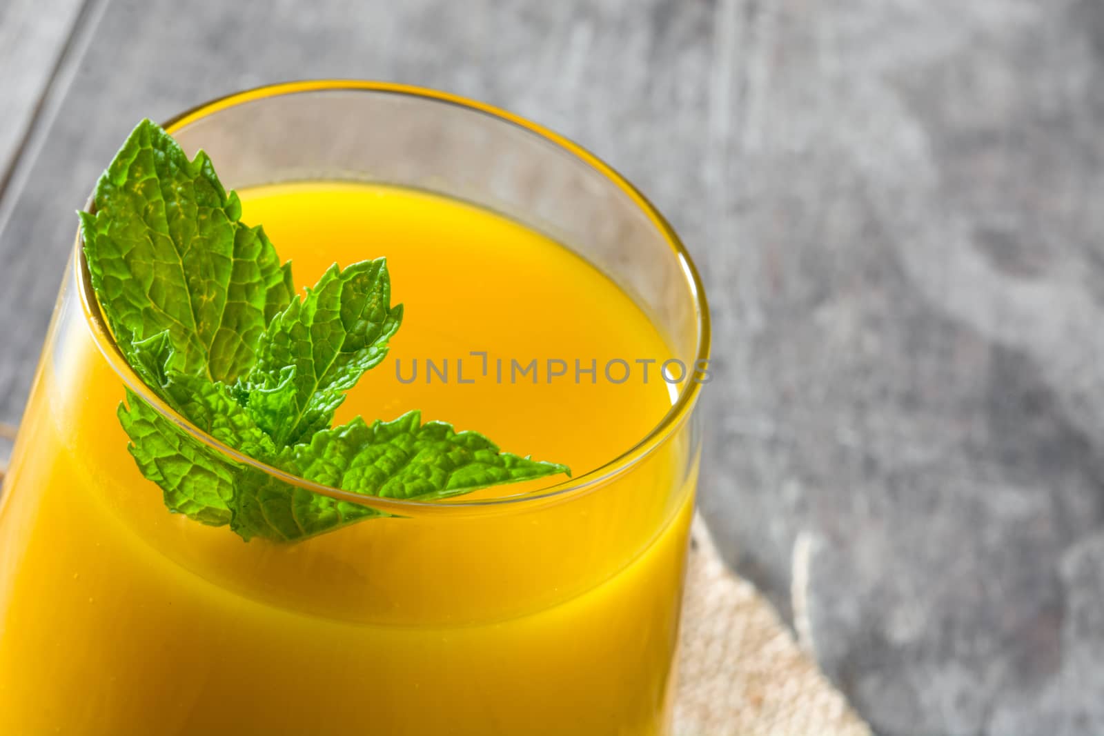 Mango Lassi dessert. Traditional Indian drink on wooden table. Copyspace