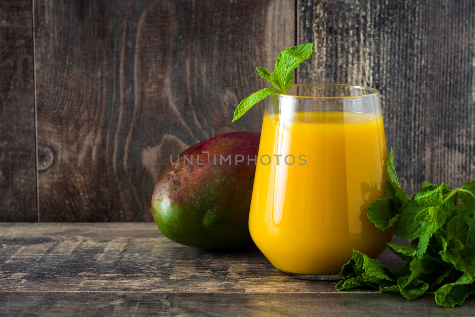 Mango Lassi dessert. Traditional Indian drink on wooden table. Copyspace