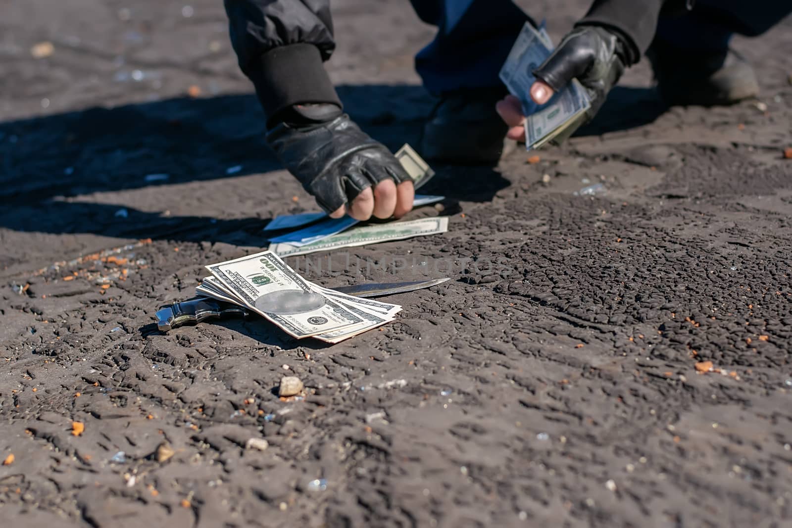 money and a knife on the road collected by human hands by jk3030