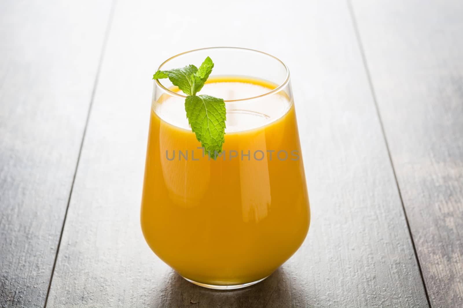 Mango Lassi dessert. Traditional Indian drink on wooden table. Copyspace