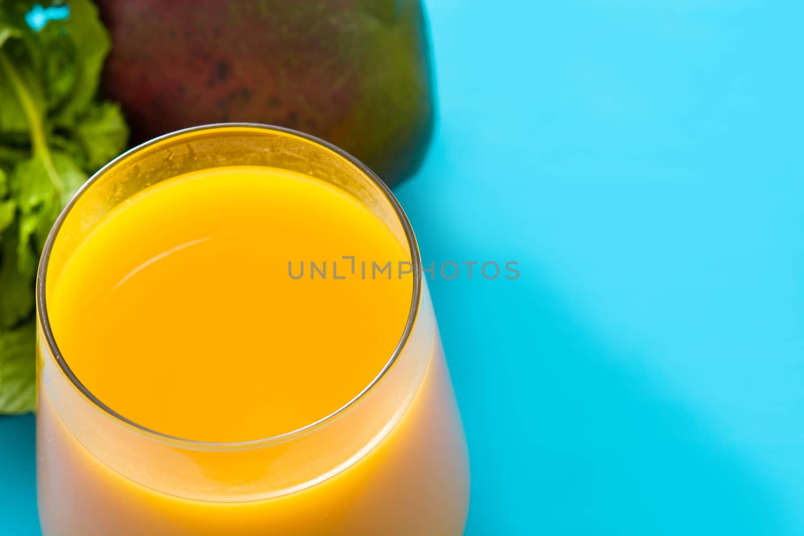 Mango Lassi dessert. Traditional Indian drink on blue background. Copyspace