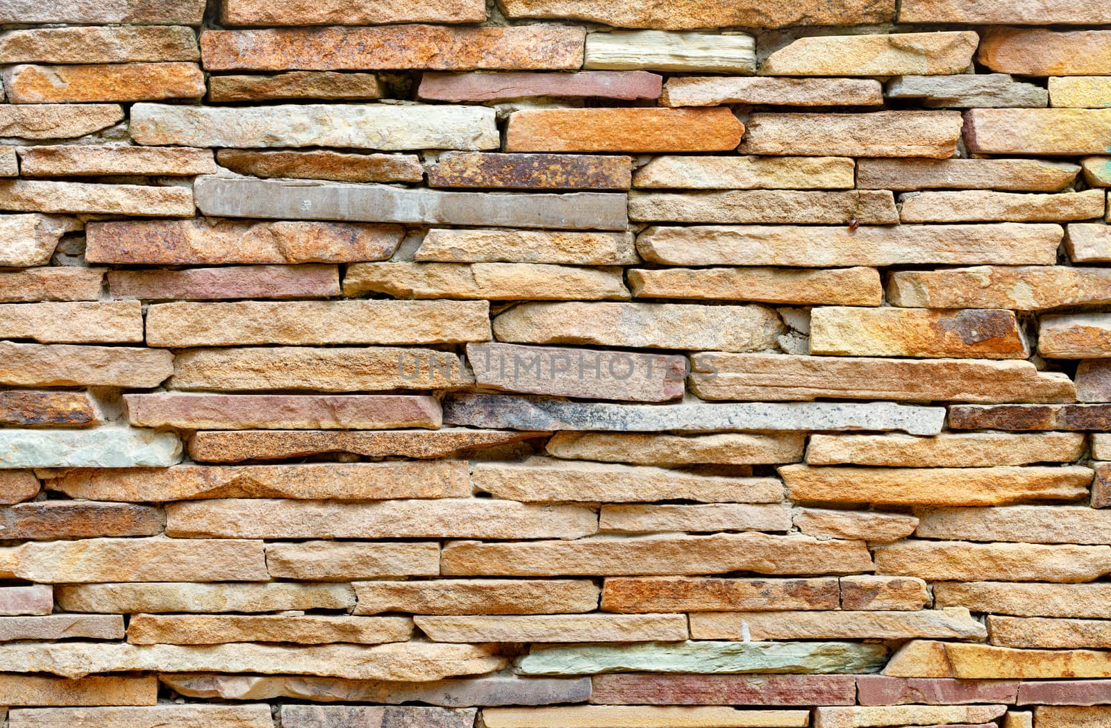 The stone wall is lined with pieces of old flat gold sandstone. by Sergii