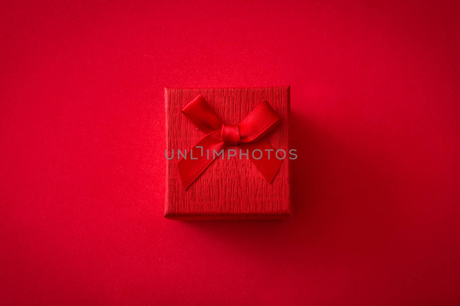 Red gift box on red background. Top view