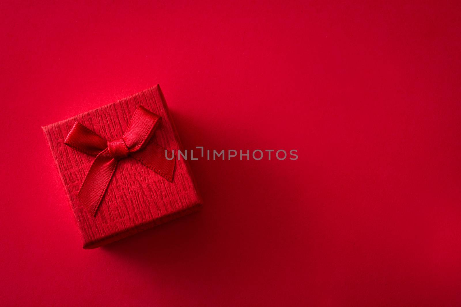 Red gift box on red background. Top view