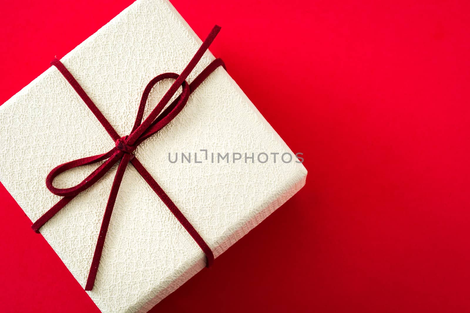 White gift box on red background. Top view