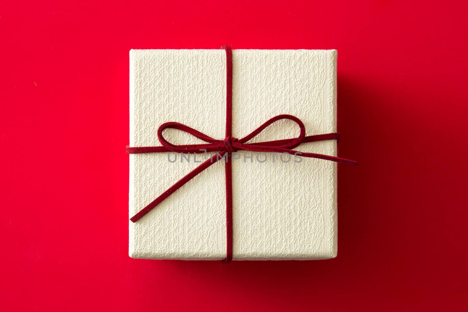 White gift box on red background. Top view