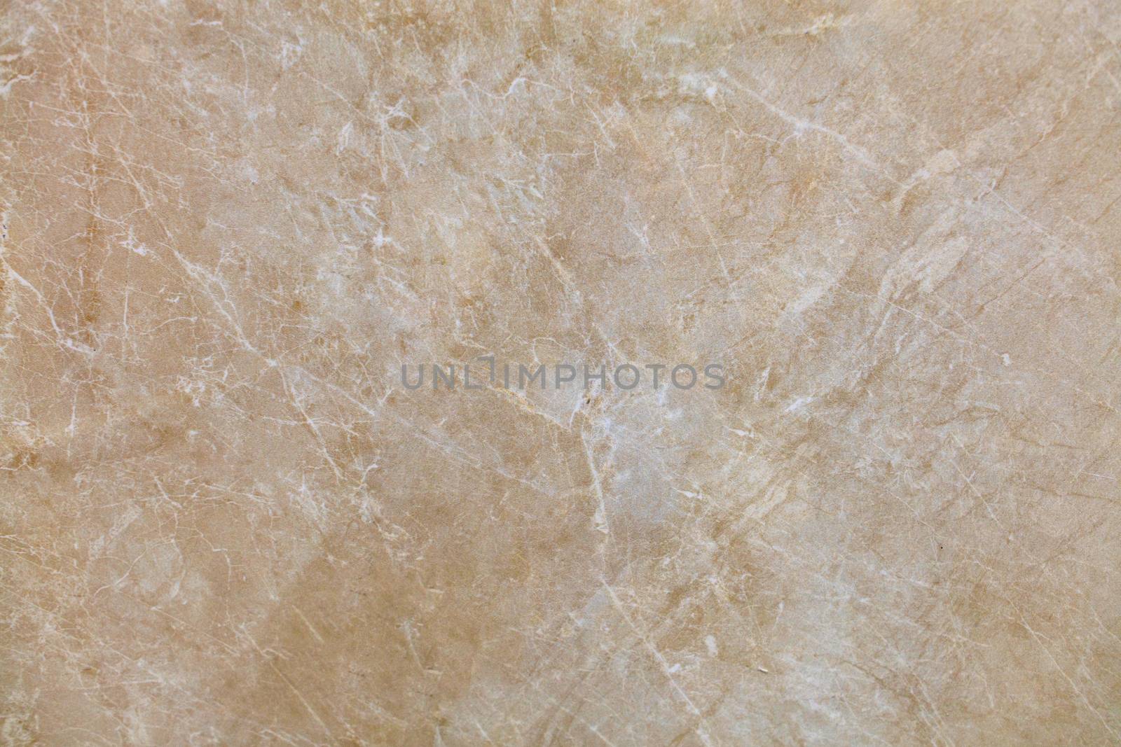 Unusual texture of old beige marble with whitish beige spots, cracks and scratches. Polished surface.