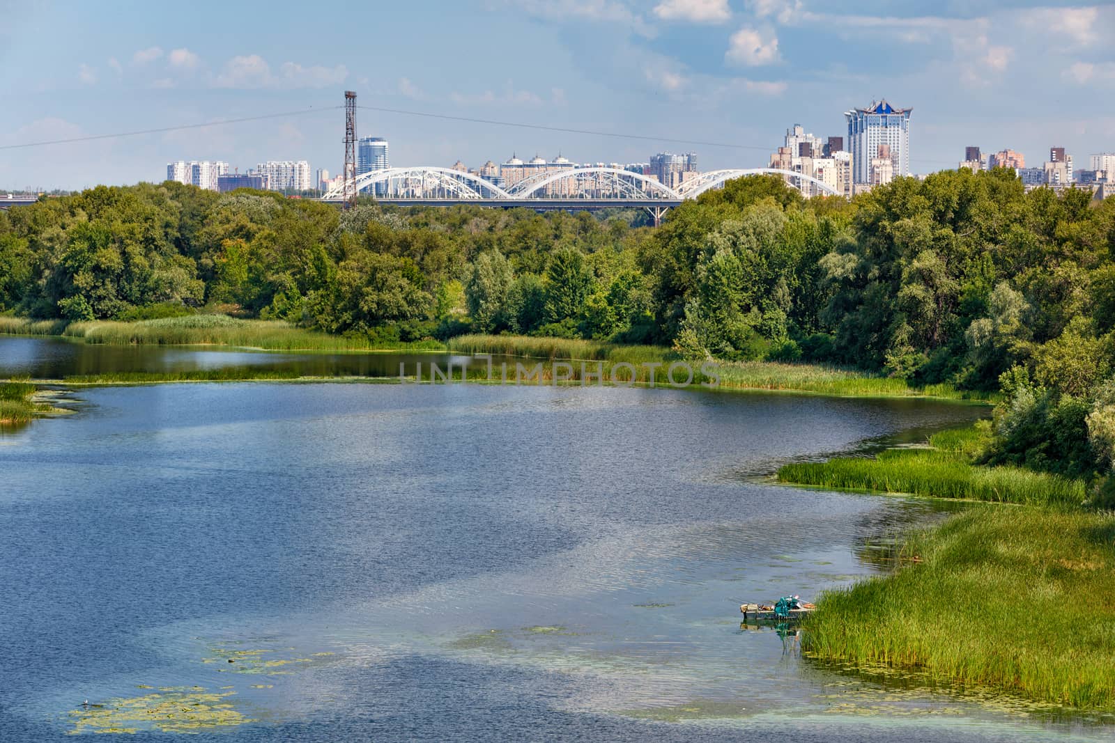 Natural picturesque landscape of the Dnieper bay near one of the river islands. An industrial city is visible in the background. by Sergii