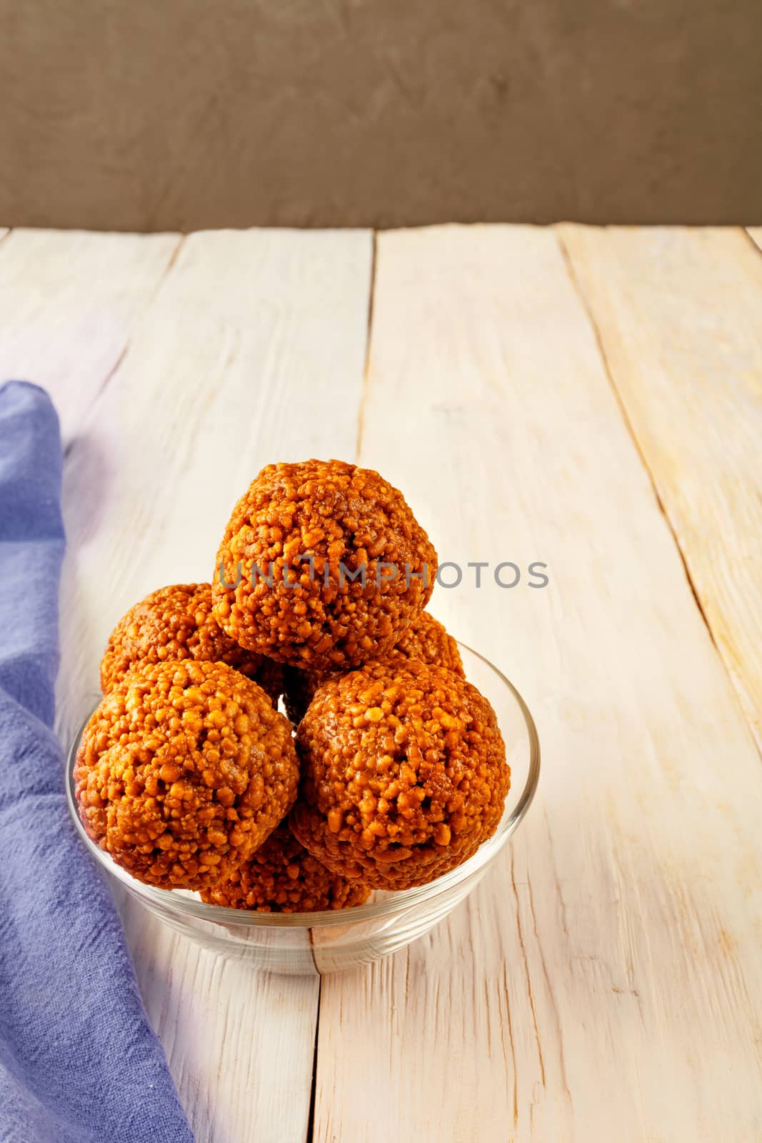 Homemade energy balls with different healthy ingredients, walnuts and honey in a glass bowl on a light wooden surface. by Sergii