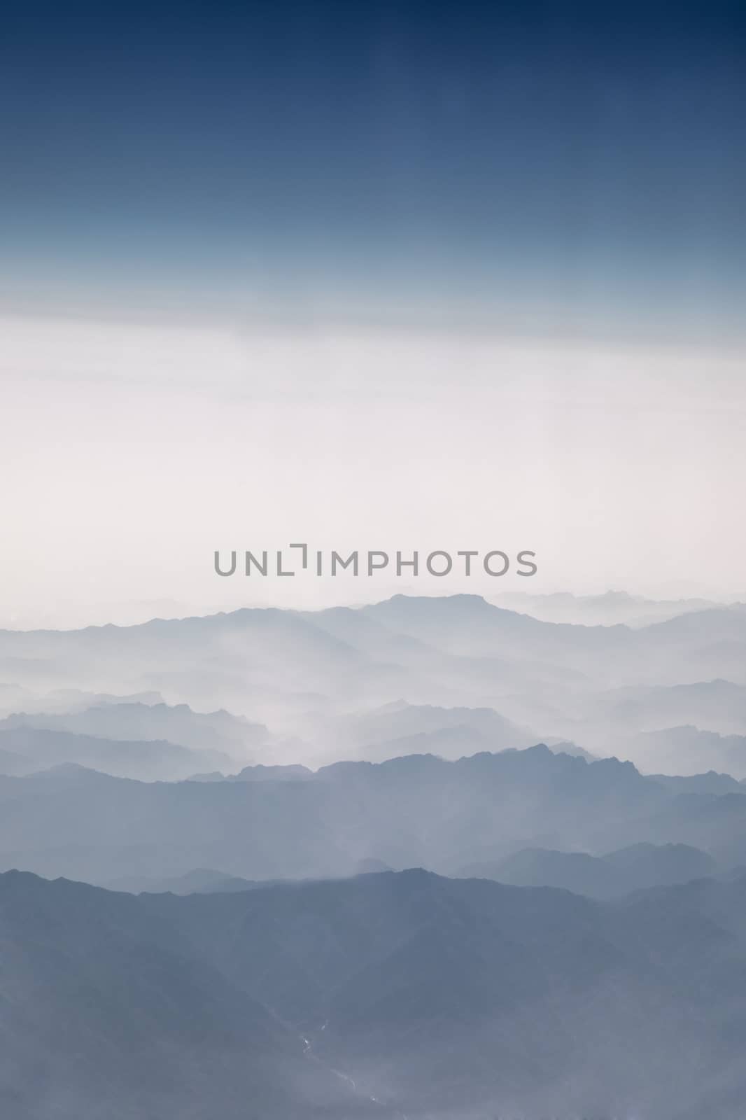 Aerial view of large mountains with mist