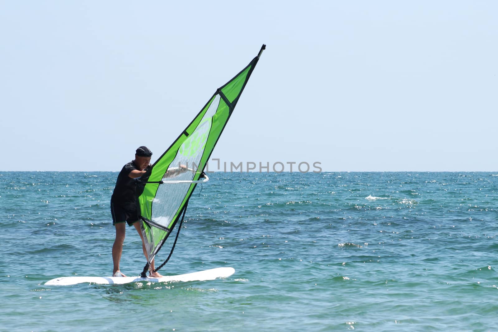 old man windsurfing in the sea