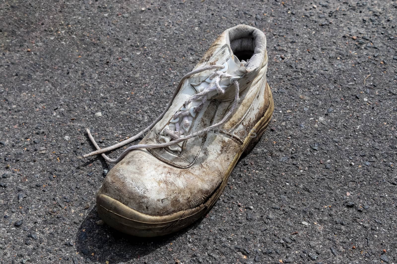 Concept of old shoes left on an ashpalt road with copy space for by MP_foto71