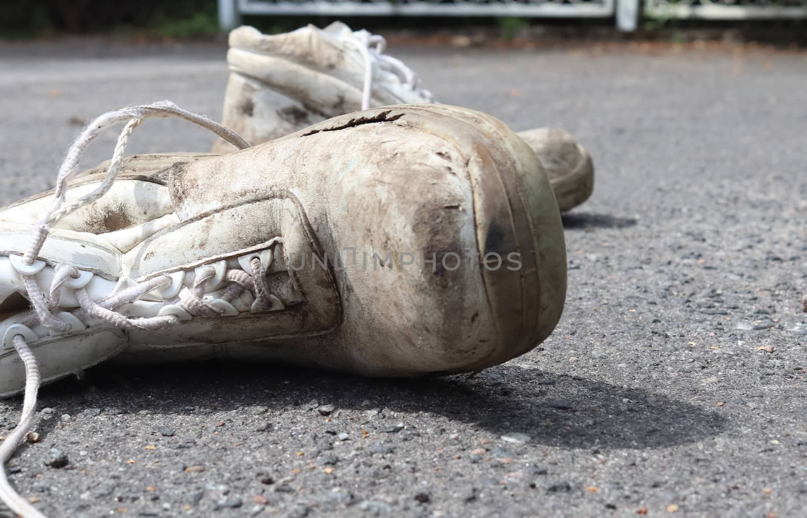 Old shoes with copy space for text left on an ashpalt road. Stylish and fashion accessories - men's wear shoes concept.