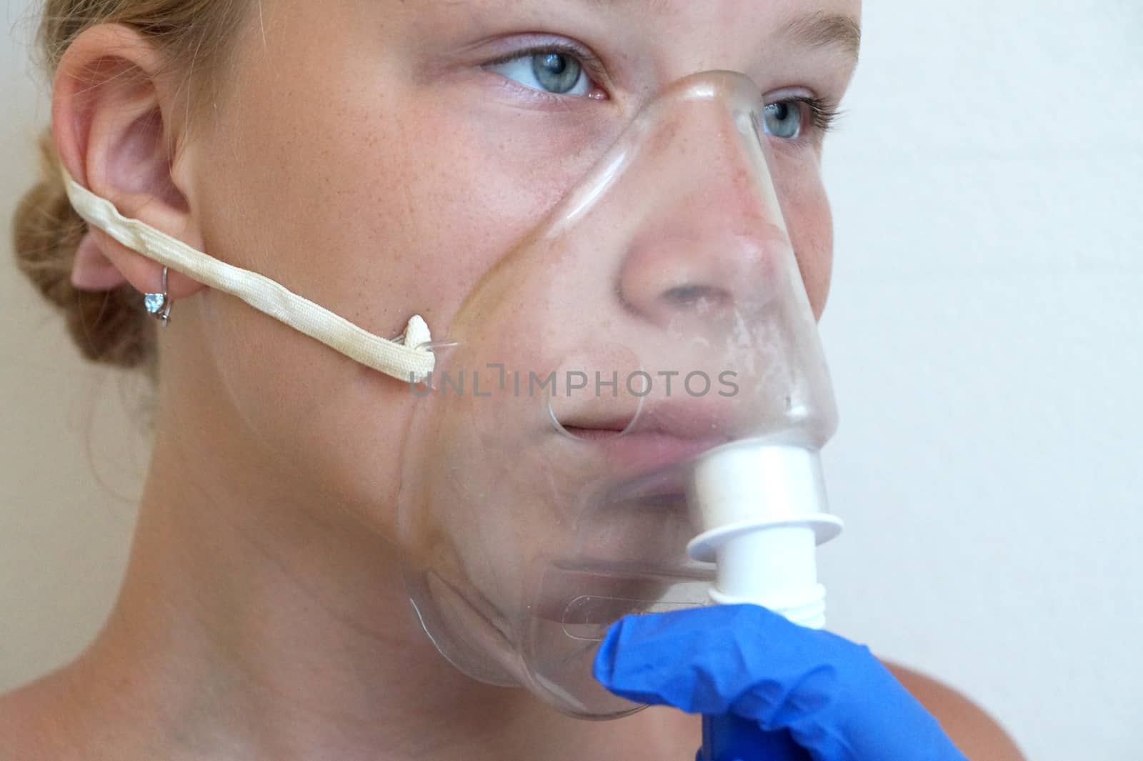 girl breathing through an inhaler, portrait close-up