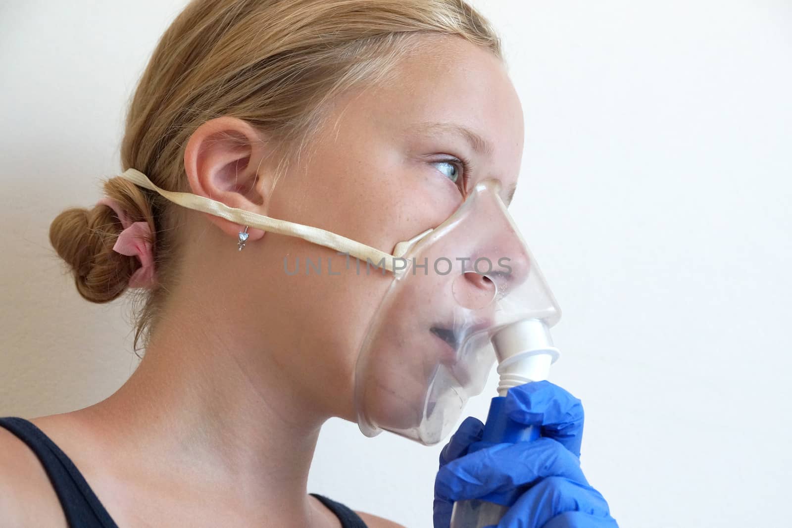 girl breathing through an inhaler, portrait close-up