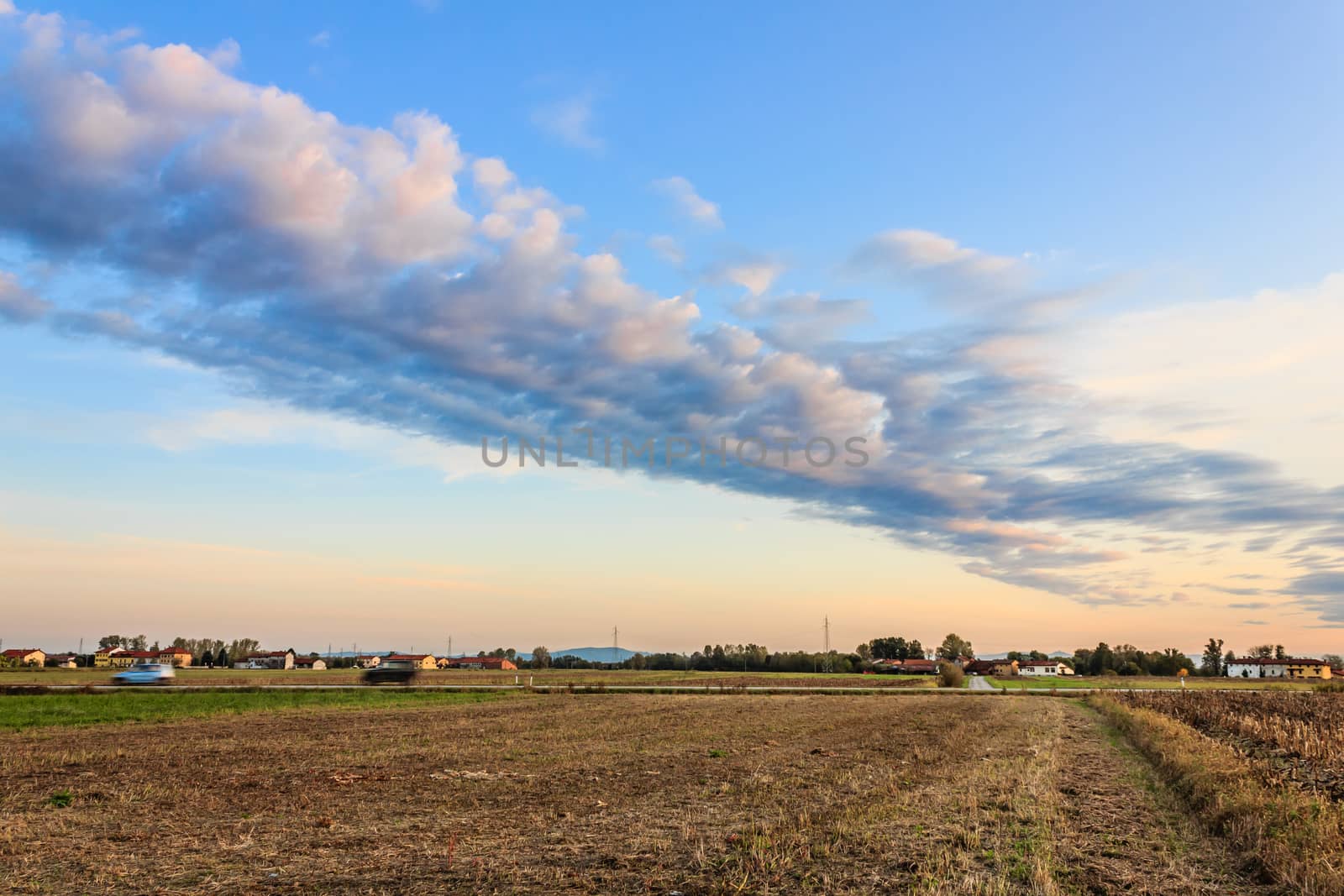 a rectilinear cloud formed at sunset in the countryside during the autumn